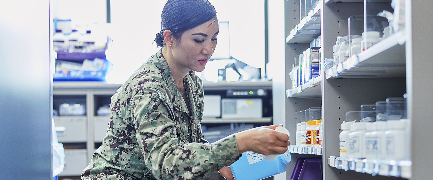 A Navy Pharmacist works with a team in the Pharmacy