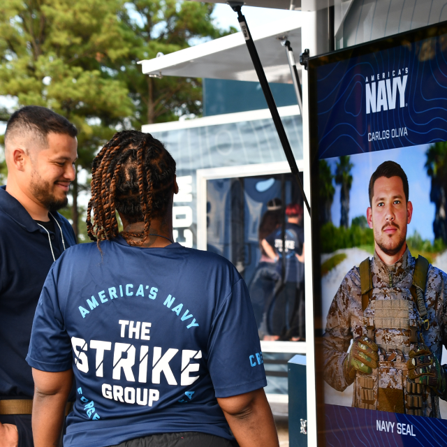 Woman and man look at career quiz results during The Strike Group experience, presented by America's navy.