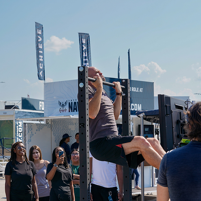 Man does a pull up at The Strike Group experience, presented by America's Navy.