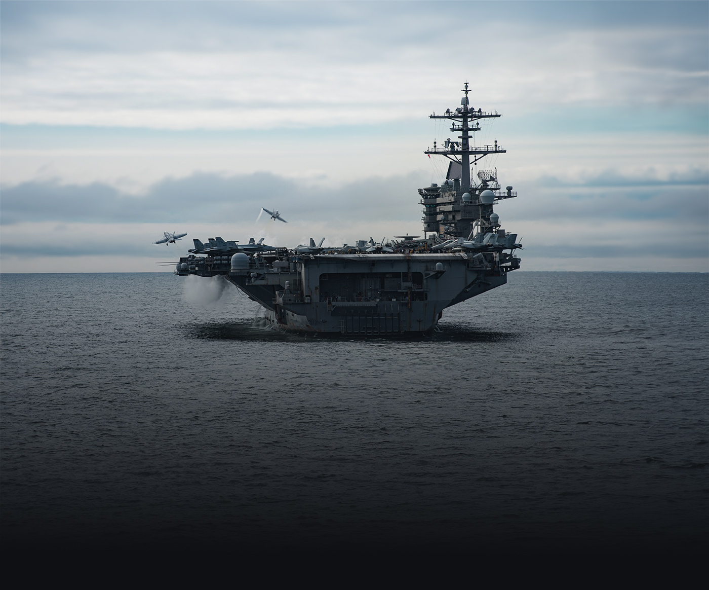 Two F/A-18 Super Hornets launch from the flight deck of the Navy aircraft carrier USS Theodore Roosevelt (CVN 71).