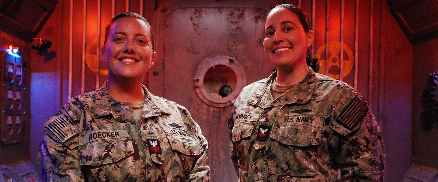 Navy Cryptologic Technicians Interpretive (CTIs) smiling and ready for a language-based escape room challenge against YouTuber Arieh Smith.