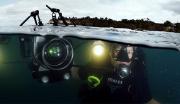 A Navy Sailor takes underwater photographs in full scuba diving gear and high-tech photo equipment.