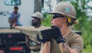 A team of Navy Sailors unload lumber for a building project.